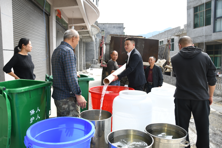 黄伟在为城南社区7组赵家坡居民送水.JPG