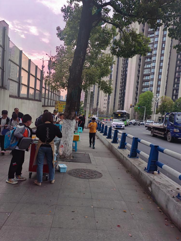 南岸区弹子石中海学校门口人行道上学生上下学的时候路两边摆满了各种