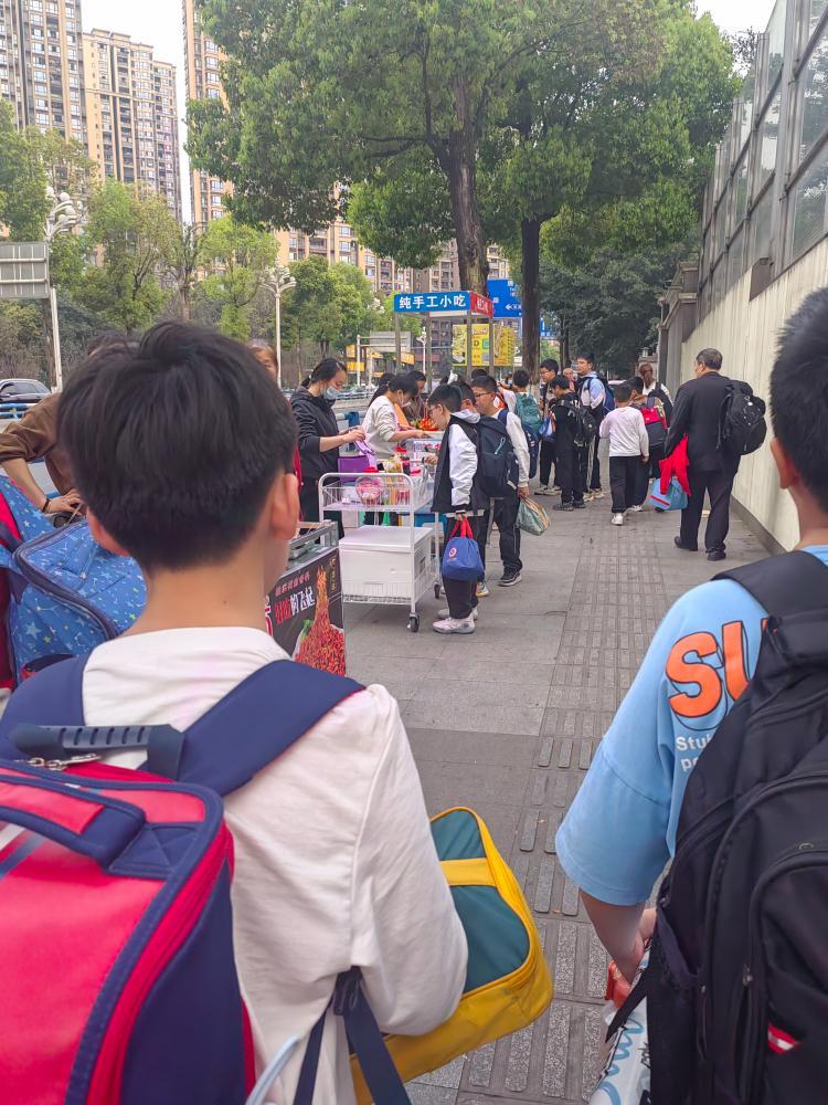 南岸区弹子石中海学校门口人行道上学生上下学的时候路两边摆满了各种