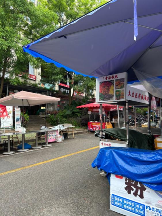 重庆财经学校校门口商家占道违规摆摊 收取摊位费