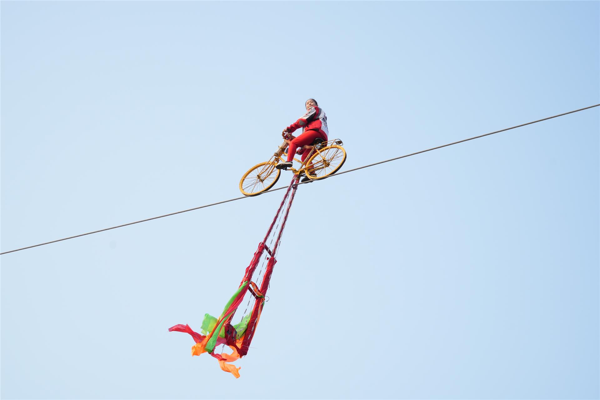摩托车飞跃钢丝,在钢丝上空中掉头 ;自行车花样表演凤凰展翅